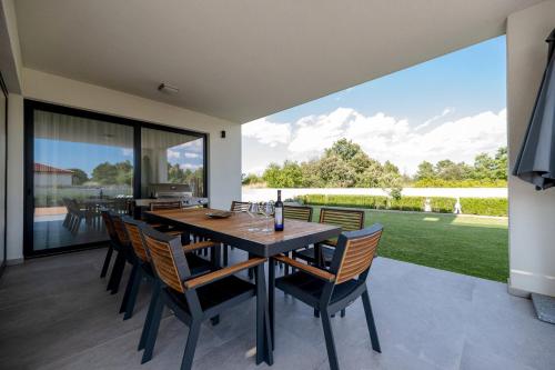 an open dining room with a table and chairs at Contemporary Zadar Villa 4 Bedrooms Villa Barako Prestige in Nin