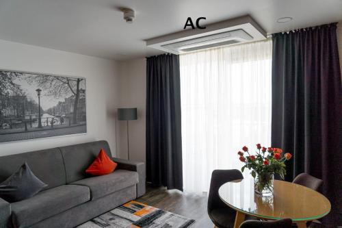 a living room with a couch and a table at Hotel Kreis Residenz München in Munich