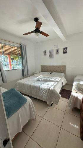 a bedroom with two beds and a ceiling fan at Sítio Maranata Vale das Montanhas in Monte Alegre do Sul