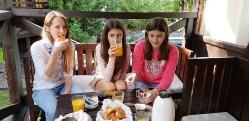 three girls sitting on a porch eating food at Complejo Aramis Chapadmalal in Chapadmalal