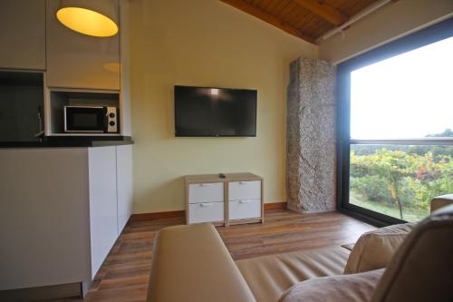 a living room with a couch and a large window at Casa Vale da Fonte in Geres