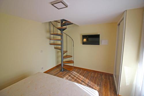 a spiral staircase in a room with a bed at Casa Vale da Fonte in Geres
