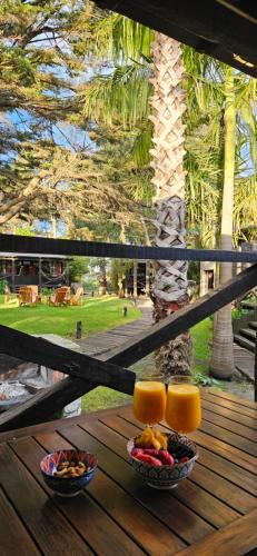 a table with two bowls of fruit and two glasses of orange juice at Complejo Aramis Chapadmalal in Chapadmalal