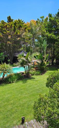 a green yard with a swimming pool and trees at Complejo Aramis Chapadmalal in Chapadmalal
