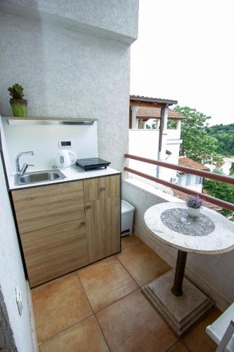 a kitchen with a sink and a table on a balcony at Guest House Jedro in Petrovac na Moru