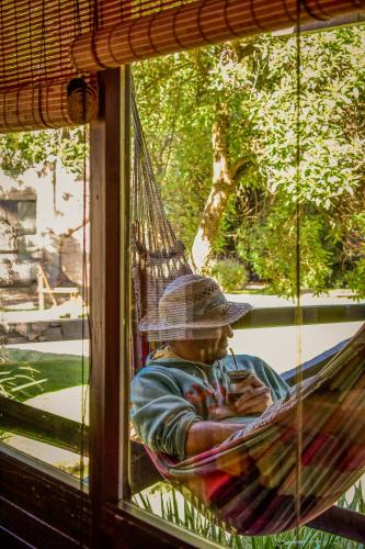 a man sitting in a hammock in a window at Complejo Aramis Chapadmalal in Chapadmalal