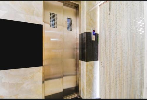 a shower door in a bathroom with a curtain at Bluestone Residence in Pānchuria