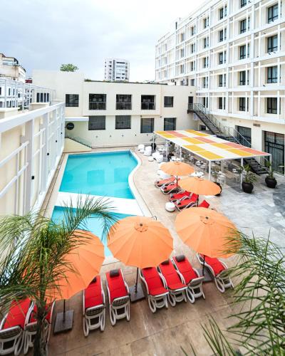 an outdoor patio with umbrellas and chairs and a pool at Barceló Fès Medina in Fez