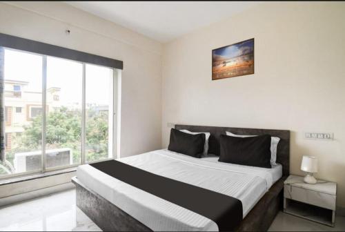 a bedroom with a large bed and a large window at Bluestone Residence in Pānchuria