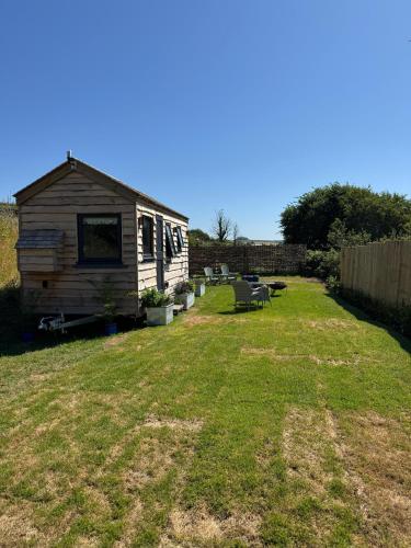a small house in a yard with a yard at The Cabin at Salcombe Farm in Salcombe