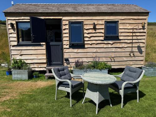 a table and chairs in front of a cabin at The Cabin at Salcombe Farm in Salcombe