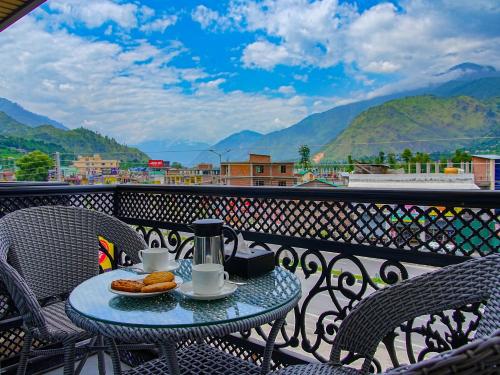 una mesa con comida y café en el balcón en Click Hotel Bhuntar, Kullu Manali -Bhuntar Airport, en Bajaura