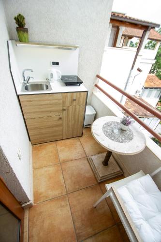 a kitchen with a sink and a table on a balcony at Guest House Jedro in Petrovac na Moru