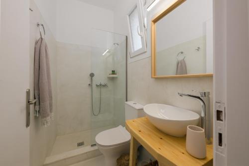 a bathroom with a sink and a toilet and a shower at Scala Apartments in Kastraki Naxou