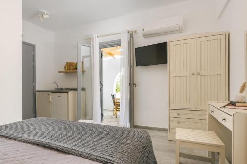 a bedroom with a bed and a door to a kitchen at Scala Apartments in Kastraki Naxou