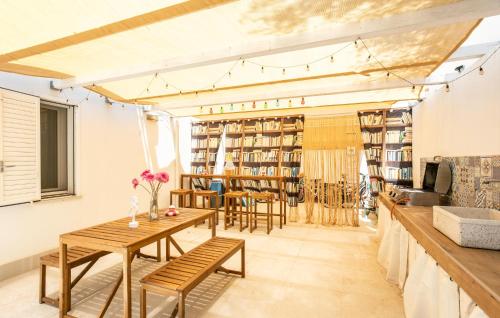 a room with tables and chairs and bookshelves at Residenza Flamingo in Marzamemi