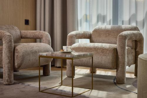a living room with two chairs and a coffee table at WestCord Hotel Eindhoven in Eindhoven