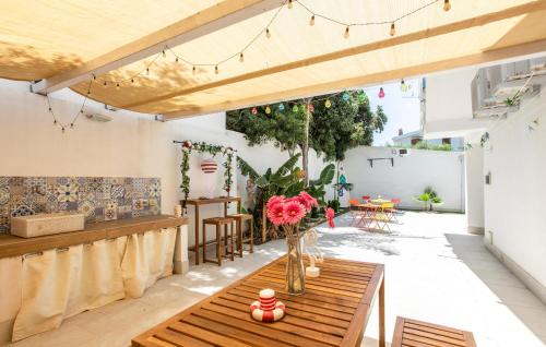 a patio with a wooden table and flowers on it at Residenza Flamingo in Marzamemi