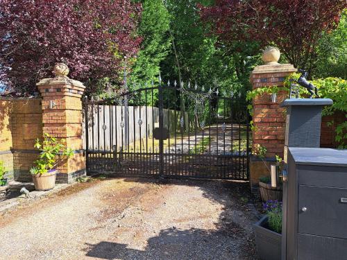 a gate to a driveway with a fence at The Stables - Deer Park Farm in Solihull