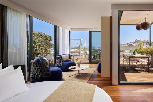 - une chambre avec un lit et une vue sur une terrasse dans l'établissement NH Collection Ibiza, à Ibiza