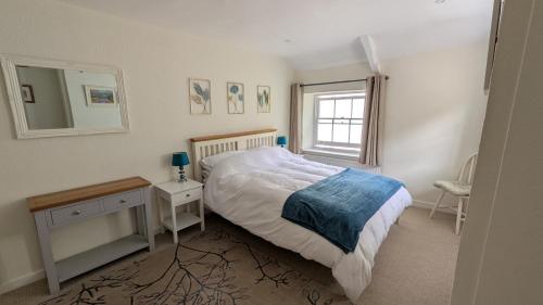 a bedroom with a bed and a table and a mirror at Hidden Gem on the Outskirts of Bristol in Keynsham