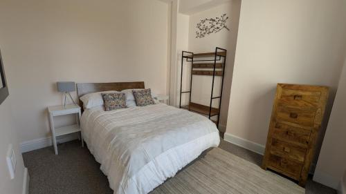 a bedroom with a bed and a wooden dresser at Hidden Gem on the Outskirts of Bristol in Keynsham