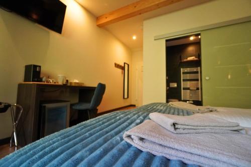 a bedroom with a bed with towels on it at Pension Sonnenheim in Gmünd in Kärnten