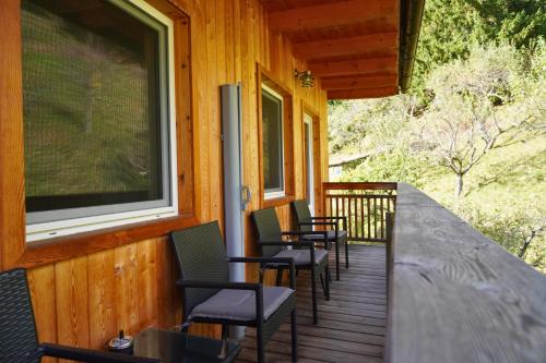 a row of chairs sitting on the porch of a cabin at Pension Sonnenheim in Gmünd in Kärnten