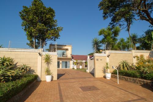 una entrada de ladrillo que conduce a una casa con árboles en Umhlanga Self Catering Guest House, en Durban