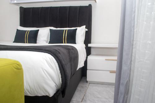 a bedroom with a large bed with a black headboard at Optimum Stay Self Catering Accommodation - Junior Suite in Parow