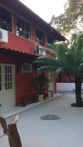 a building with a palm tree in front of it at Pitanga Ilha Grande in Abraão