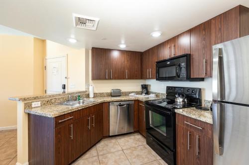 a kitchen with wooden cabinets and stainless steel appliances at The Grandview at Las Vegas in Las Vegas