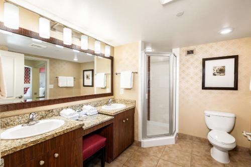 a bathroom with two sinks and a toilet and a shower at The Grandview at Las Vegas in Las Vegas