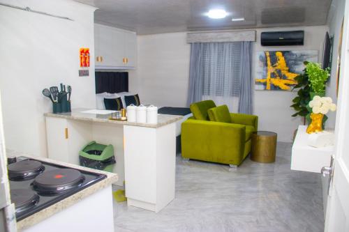 a living room with a kitchen and a green chair at Optimum Stay Self Catering Accommodation - Junior Suite in Parow