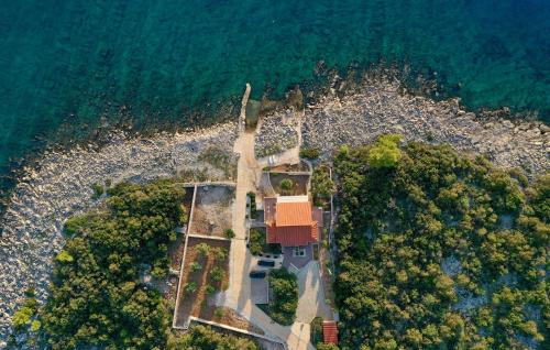 an aerial view of a house on a rocky beach at Holiday Home Zastrazisce With Sea View 04 in Selca kod Bogomolja