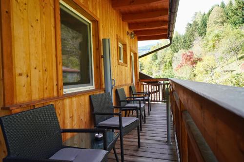 a row of chairs sitting on the porch of a cabin at Pension Sonnenheim in Gmünd in Kärnten