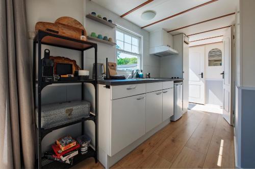 a kitchen with white cabinets and a black shelf at 27, Beekse Bergen, Efteling, Woods, Private Parking! in Oisterwijk