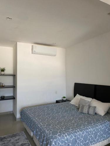 a bedroom with a bed with a blue comforter at Lovely loft with pool in center! in Cancún