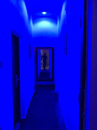 a blue room with a hallway with a blue light at Royal Suite in Jidu