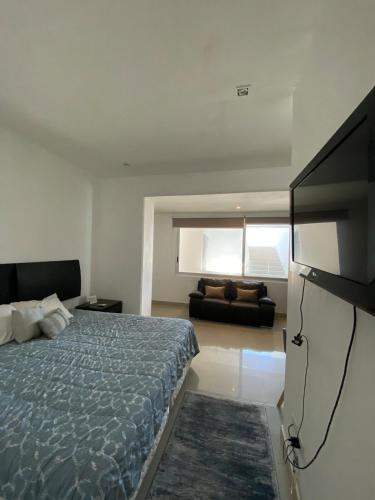a bedroom with a bed and a flat screen tv at Lovely loft with pool in center! in Cancún