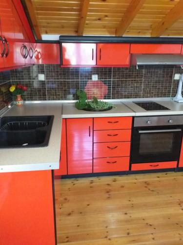 a kitchen with red cabinets and a sink at ViLLA DRAGANI in Sikia