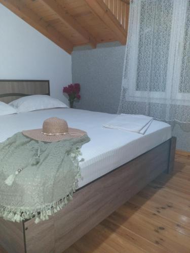 a bed with a straw hat on top of it at ViLLA DRAGANI in Sikia