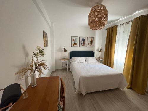 a bedroom with a bed and a table and a desk at El Patio Grande in Menasalbas