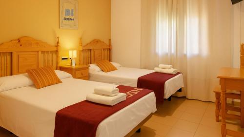 a hotel room with two beds with towels on them at Hostal Valdepeñas by Bossh! Hotels in Valdepeñas