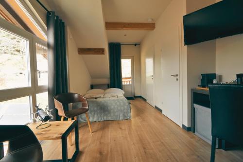 a bedroom with a bed and a desk and a window at Pension Sonnenheim in Gmünd in Kärnten