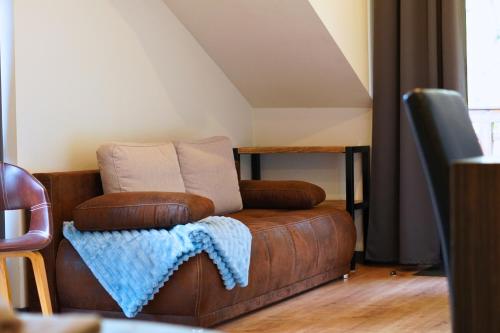 a brown leather couch sitting in a living room at Pension Sonnenheim in Gmünd in Kärnten
