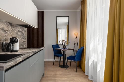 a kitchen with blue chairs and a table in a room at P6-A Riga Old Town Apartments in Rīga