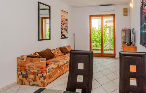 a living room with a couch and a tv at Cozy Apartment In Nin With Wifi in Nin