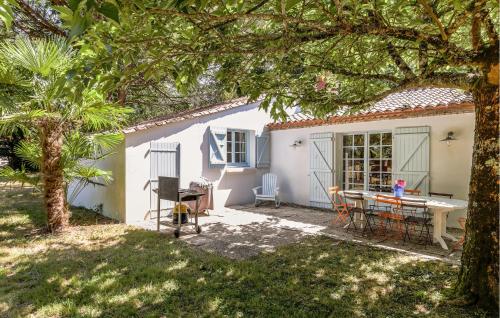 a small white house with a table in a yard at Amazing Home In La Boissières Des Land in Saint-Avaugourd-des-Landes