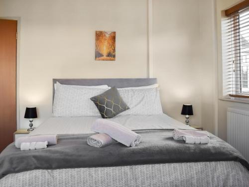 a bedroom with a bed with two towels on it at Lyncroft Holiday Bungalow in Sandbach